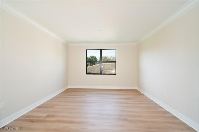 empty room with baseboards, light wood-type flooring, and crown molding