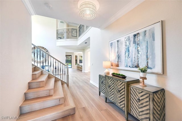 stairs featuring crown molding, baseboards, and wood finished floors