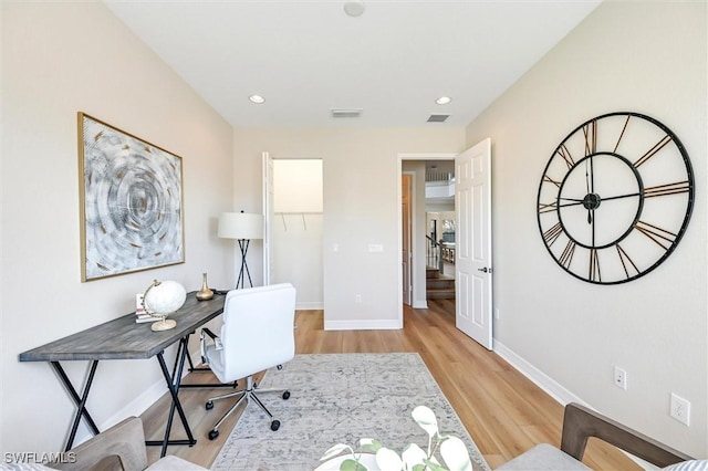 office space featuring light wood finished floors, recessed lighting, visible vents, and baseboards