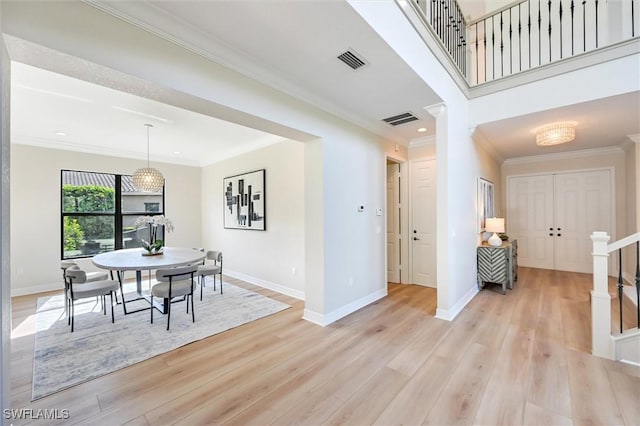 dining area featuring ornamental molding, light wood-type flooring, and visible vents