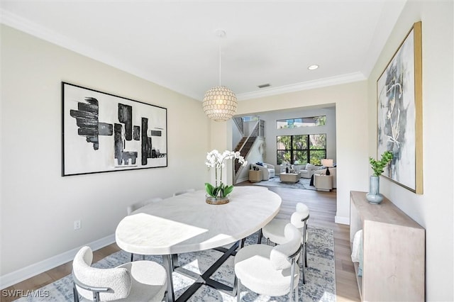 dining space with ornamental molding, baseboards, and wood finished floors