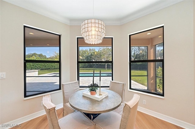 dining room with baseboards, crown molding, wood finished floors, and an inviting chandelier