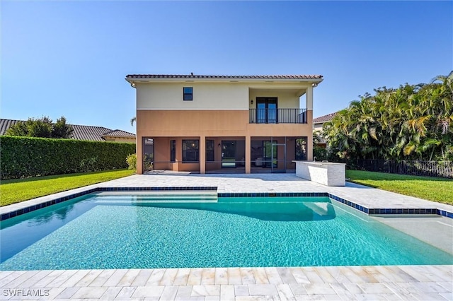 back of property with a fenced in pool, a patio, a balcony, and stucco siding