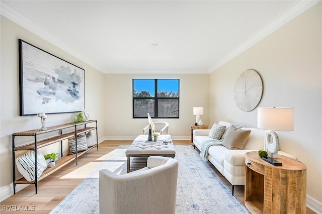 living area with light wood-style floors, baseboards, and ornamental molding