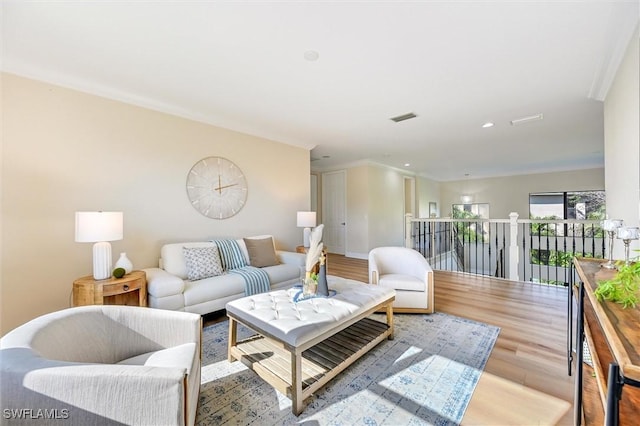 living area featuring recessed lighting, visible vents, and wood finished floors