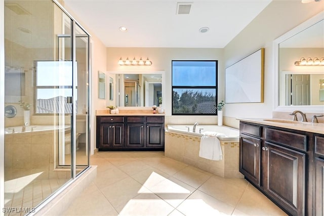 bathroom with a wealth of natural light, visible vents, a sink, and tile patterned floors