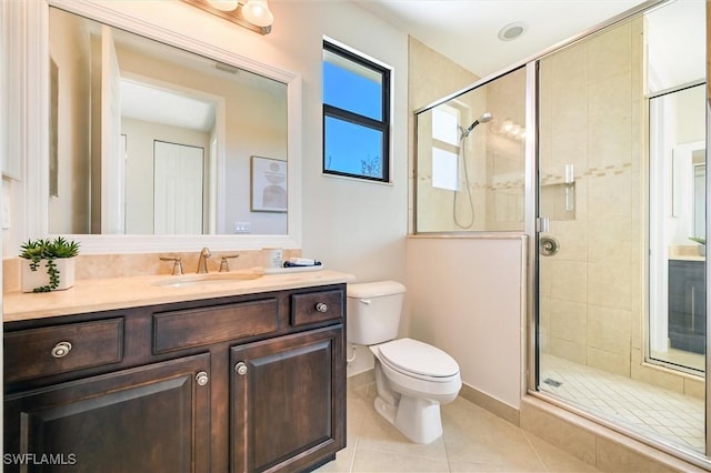 bathroom featuring toilet, a stall shower, vanity, tile patterned flooring, and baseboards