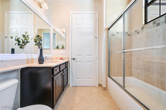 full bath featuring toilet, tile patterned flooring, combined bath / shower with glass door, and vanity