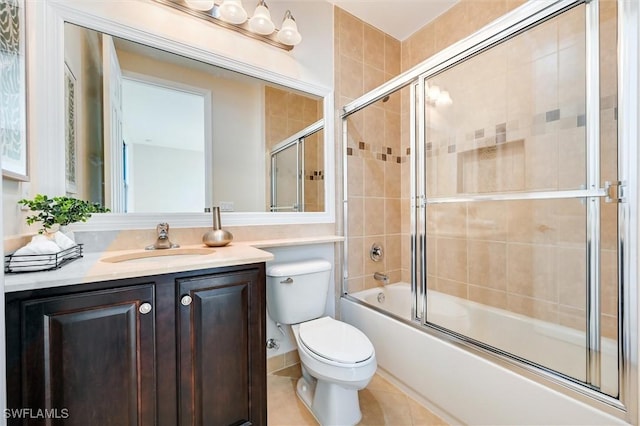 full bath with bath / shower combo with glass door, vanity, toilet, and tile patterned floors