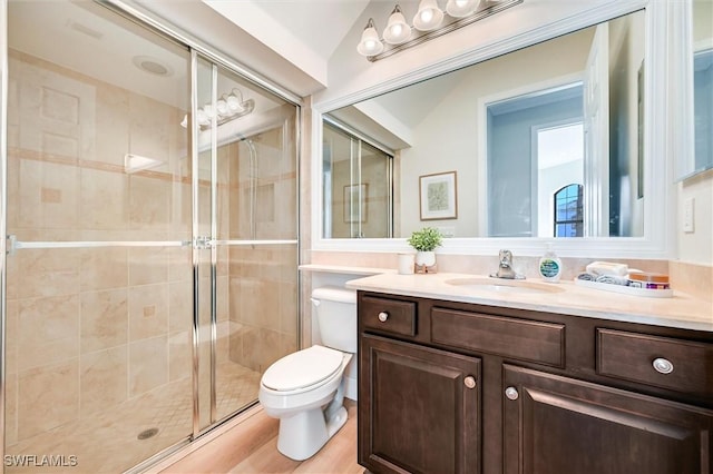 bathroom with a stall shower, vanity, and toilet