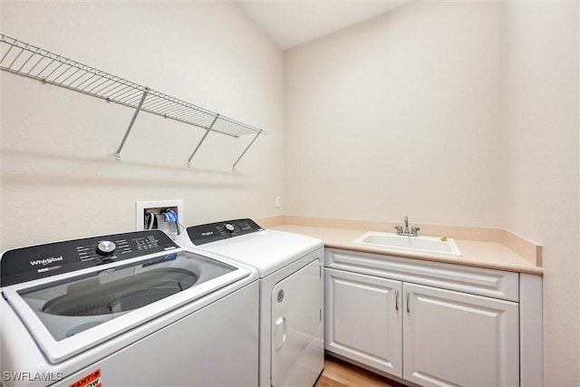 laundry area with cabinet space, a sink, and independent washer and dryer