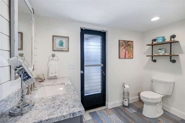 1416 SW 52nd Ter, Cape Coral, FL 33914 - bathroom featuring toilet, vanity, wood finished floors, baseboards, and recessed lighting