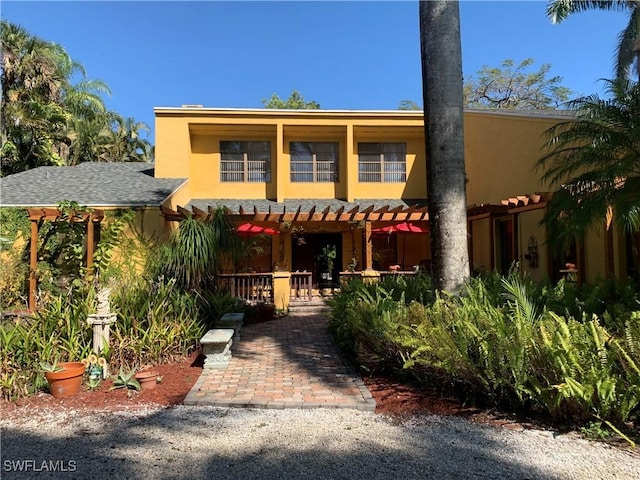 view of front of home with stucco siding and a pergola