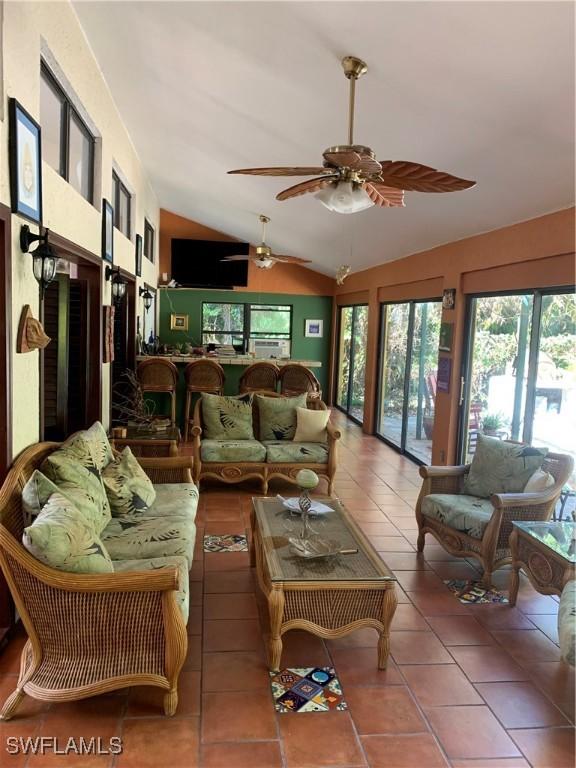 sunroom with a ceiling fan and lofted ceiling