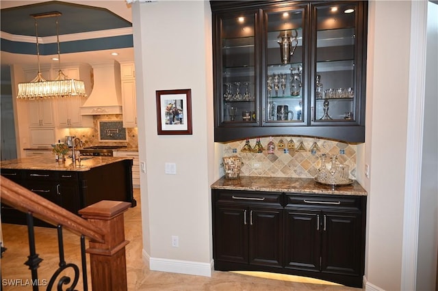 bar with decorative light fixtures, crown molding, a dry bar, custom exhaust hood, and baseboards