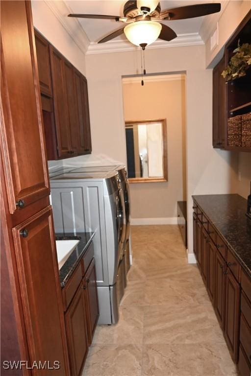 washroom featuring washing machine and dryer, cabinet space, crown molding, and ceiling fan