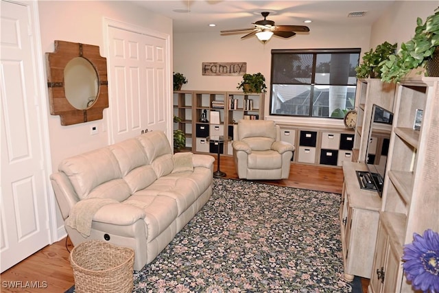 living room featuring ceiling fan, visible vents, and wood finished floors