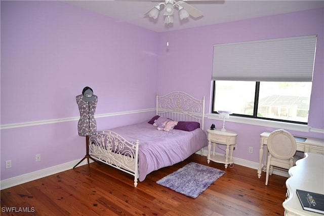 bedroom featuring ceiling fan, baseboards, and wood finished floors