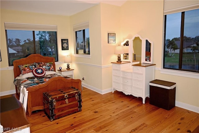 bedroom with light wood-type flooring and baseboards