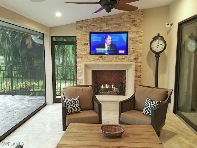 sitting room with a large fireplace and vaulted ceiling