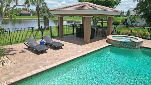 view of swimming pool with an in ground hot tub, a water view, and fence