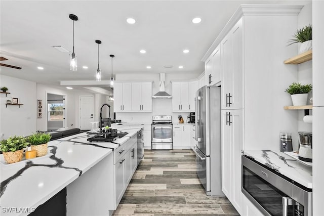 kitchen featuring decorative light fixtures, white cabinetry, recessed lighting, stainless steel appliances, and light wood-style floors