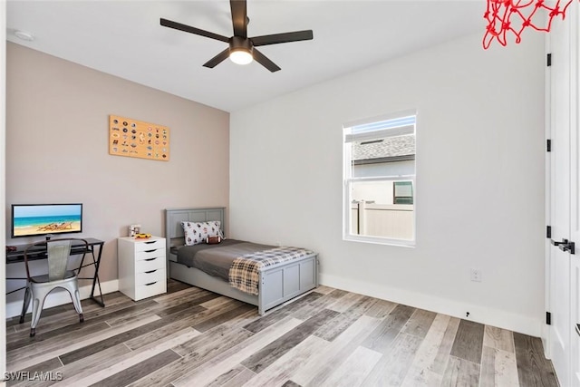 bedroom featuring a ceiling fan, wood finished floors, and baseboards