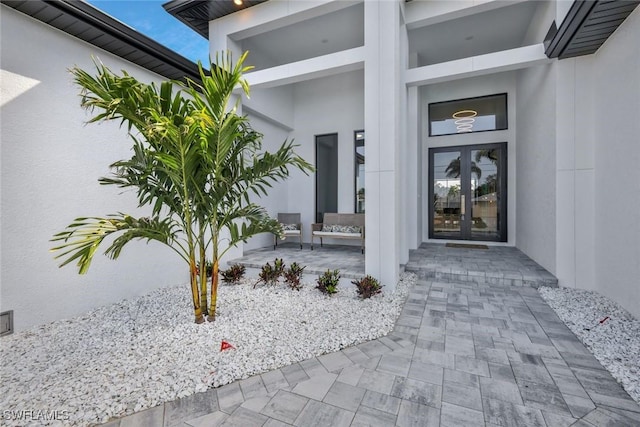 doorway to property featuring stucco siding and french doors