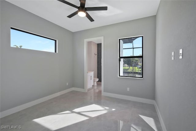 unfurnished bedroom featuring baseboards, a ceiling fan, and ensuite bathroom