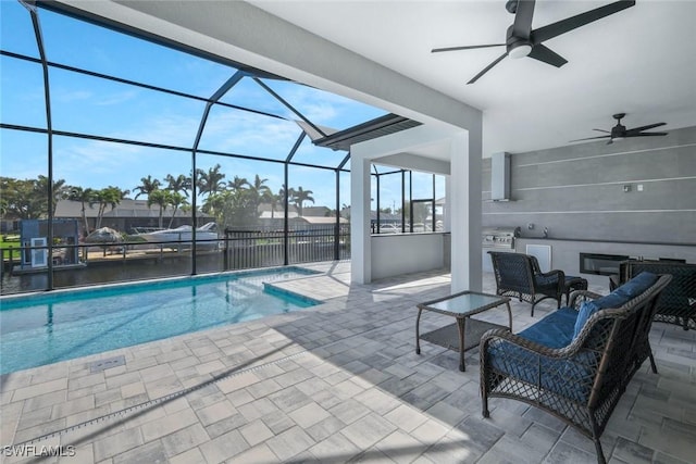 pool featuring a lanai, a ceiling fan, exterior kitchen, and a patio