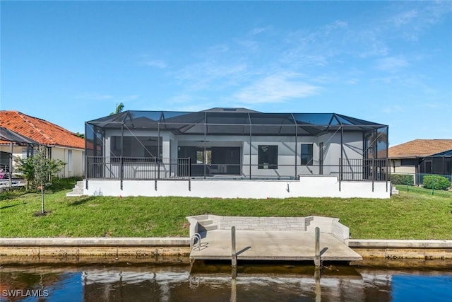 rear view of property with a water view and a lawn