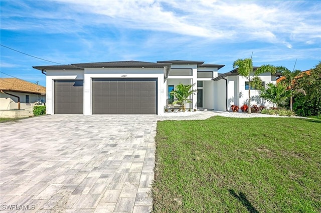 view of front facade featuring stucco siding, a front lawn, decorative driveway, and a garage