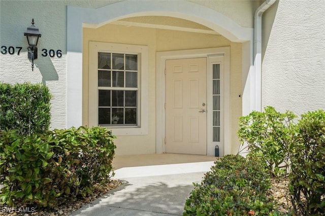 doorway to property featuring stucco siding