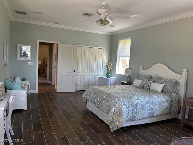 bedroom with wood tiled floor, visible vents, a closet, and ornamental molding