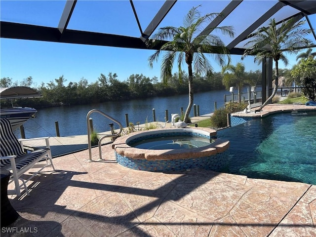 view of pool featuring a lanai, a water view, and a pool with connected hot tub