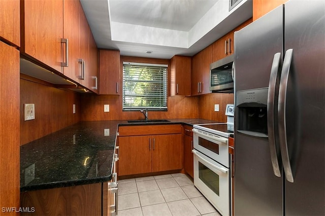 kitchen with brown cabinets, light tile patterned floors, stainless steel appliances, decorative backsplash, and a sink