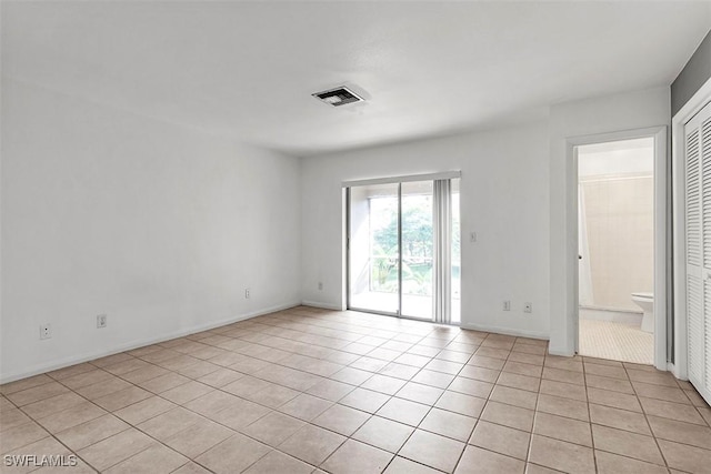 spare room featuring light tile patterned floors and visible vents