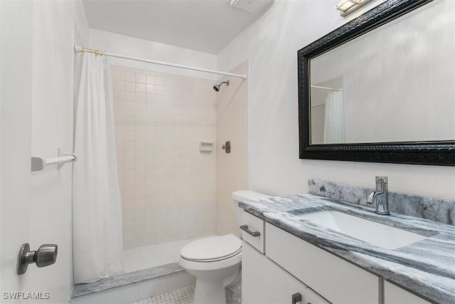 bathroom with toilet, tile patterned floors, a tile shower, and vanity