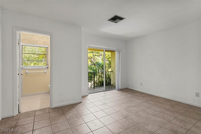 unfurnished room featuring a healthy amount of sunlight, light tile patterned floors, baseboards, and visible vents