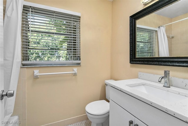 bathroom with curtained shower, baseboards, vanity, and toilet