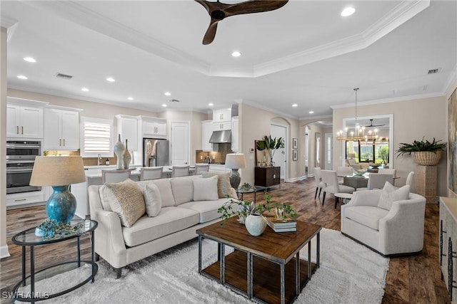 living room featuring recessed lighting, visible vents, arched walkways, and wood finished floors