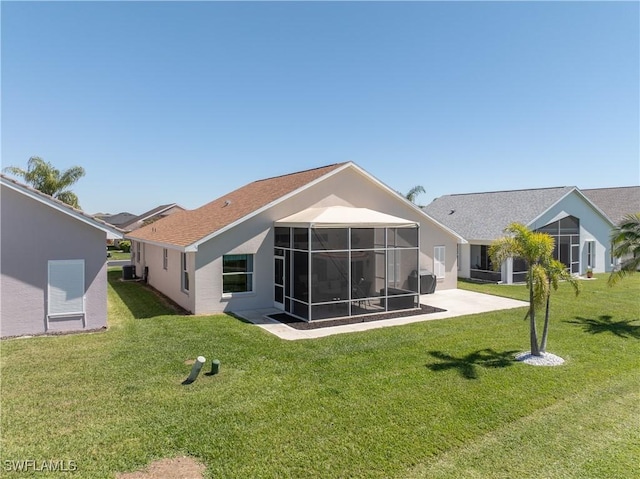 back of property with a patio, a lawn, a sunroom, and stucco siding