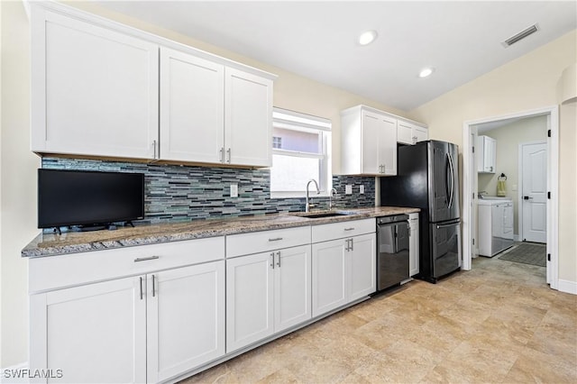 kitchen with washing machine and clothes dryer, visible vents, black appliances, white cabinetry, and a sink