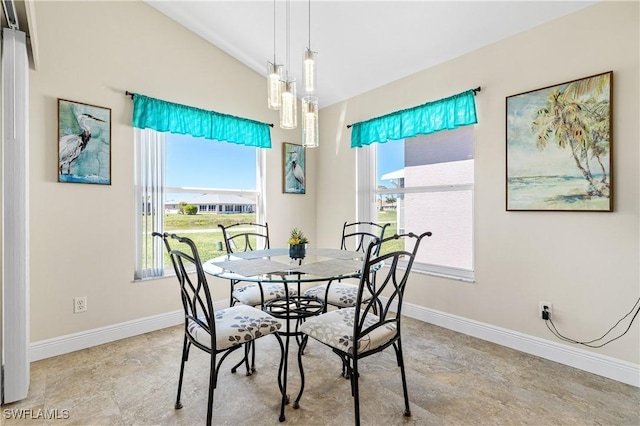 dining area featuring vaulted ceiling, plenty of natural light, and baseboards