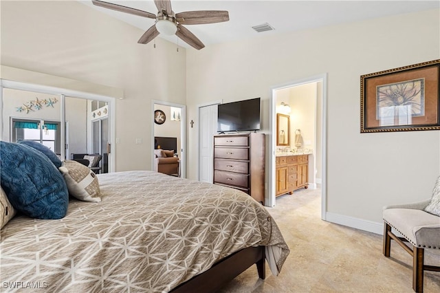 bedroom with visible vents, connected bathroom, baseboards, a towering ceiling, and a ceiling fan