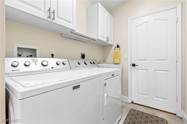 laundry room featuring light tile patterned flooring, cabinet space, baseboards, and washing machine and clothes dryer