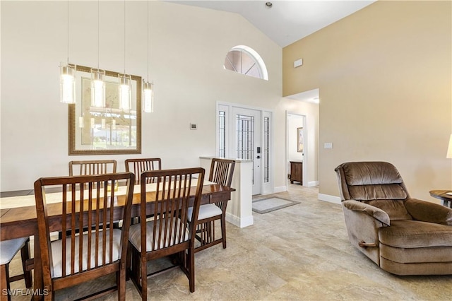 dining area featuring high vaulted ceiling and baseboards