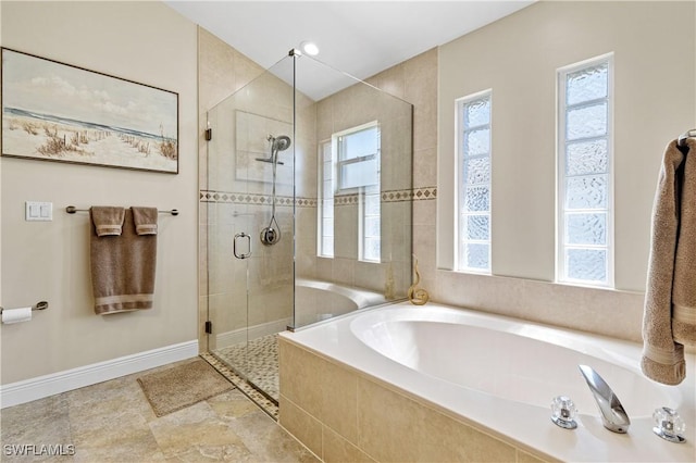 full bath with a shower stall, a garden tub, baseboards, and plenty of natural light