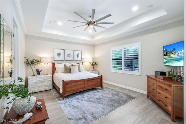 bedroom featuring a tray ceiling, visible vents, crown molding, and baseboards