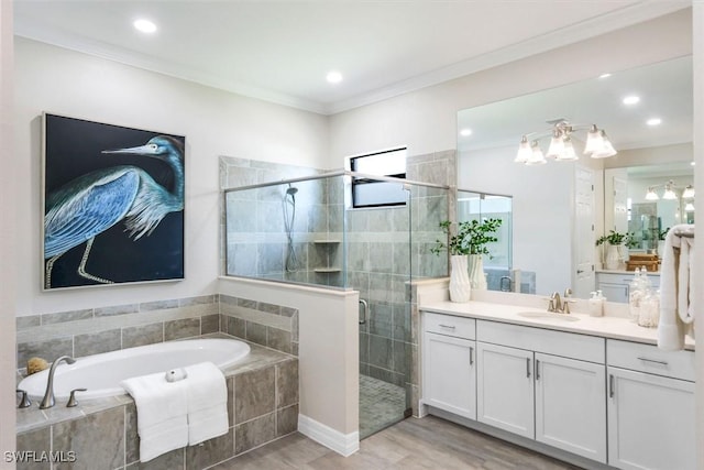 bathroom featuring a garden tub, ornamental molding, a shower stall, and vanity